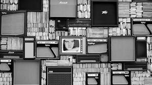 Vintage amplifiers and vinyl records arranged in a striking black and white pattern.